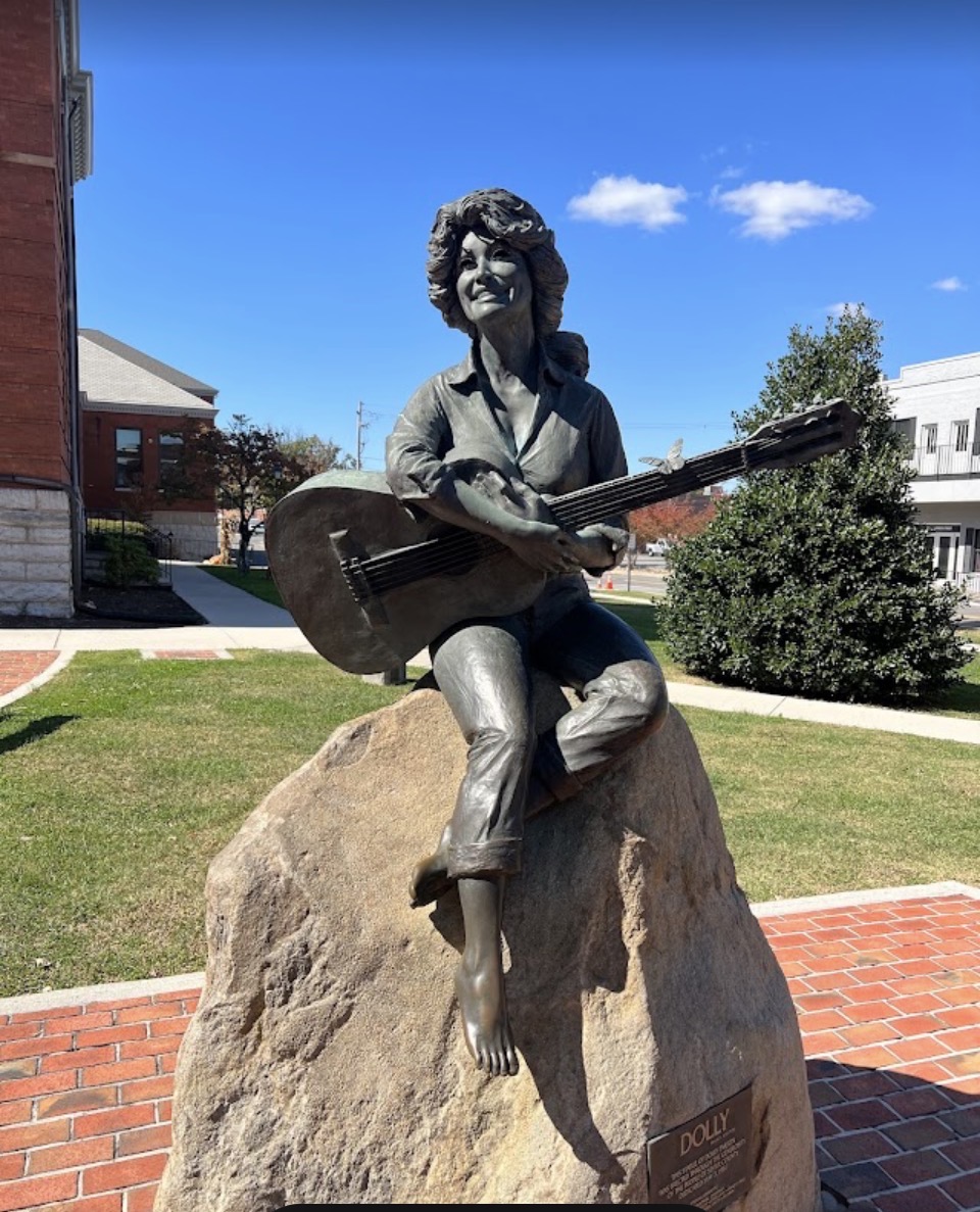 The bronze statue of a young Dolly Parton with her guitar on the Sevier County courthouse lawn in Sevierville, Tennessee