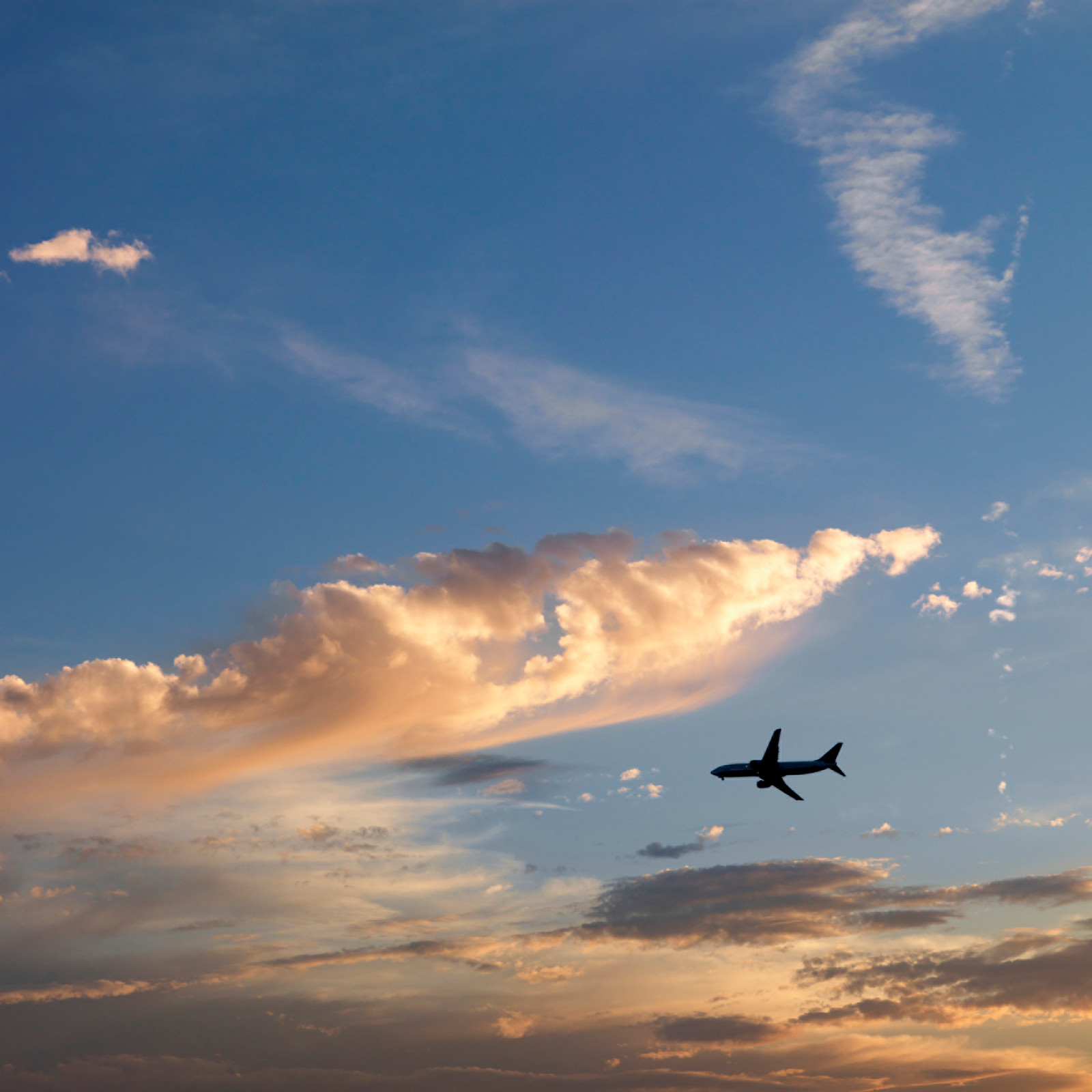 A private jet flying beneath a sunset sky before a round the world expedition
