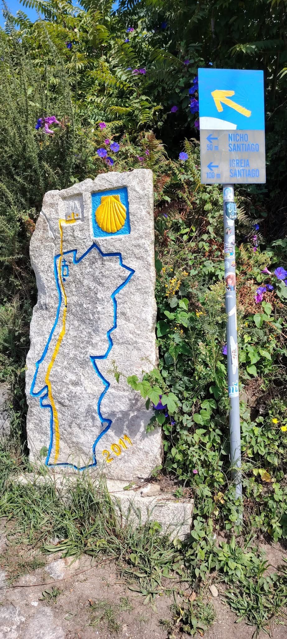 A yellow arrow and scallop shell waymarker on the Camino de Santiago