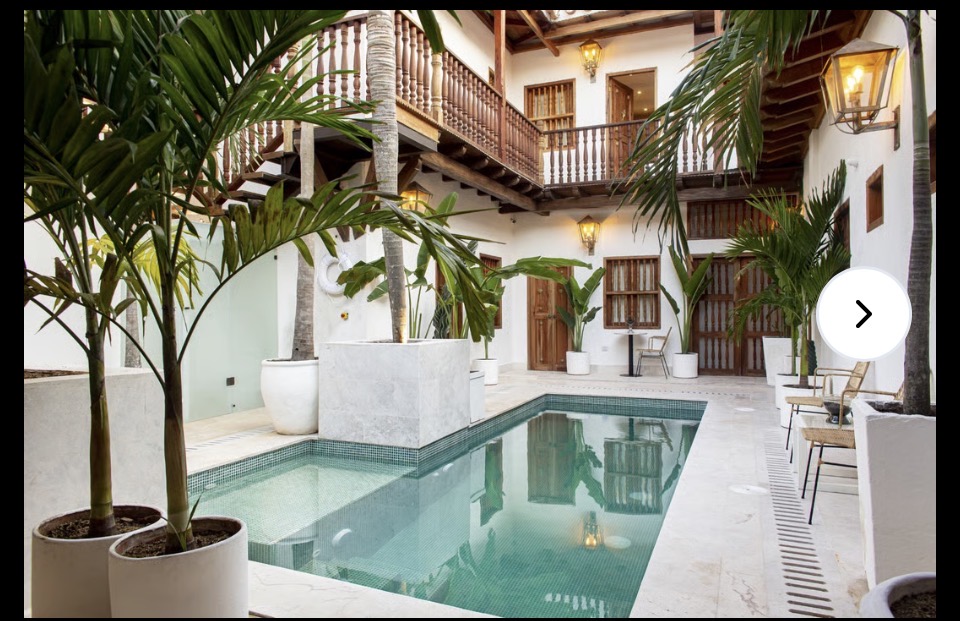 A private courtyard plunge pool surrounded by tropical palms inside a colonial mansion in Cartagena