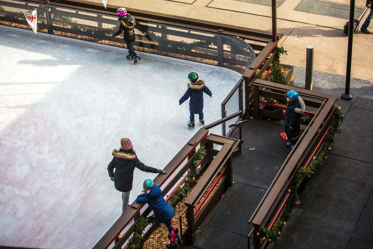 Children ice skating at an outdoor Christmas rink in Vienna