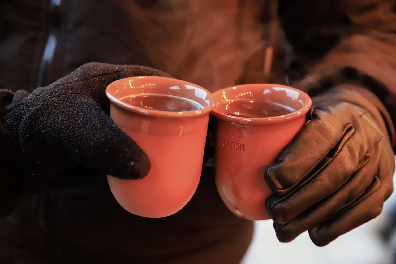 Hands holding a ceramic Christmas market mug of hot punch in Vienna