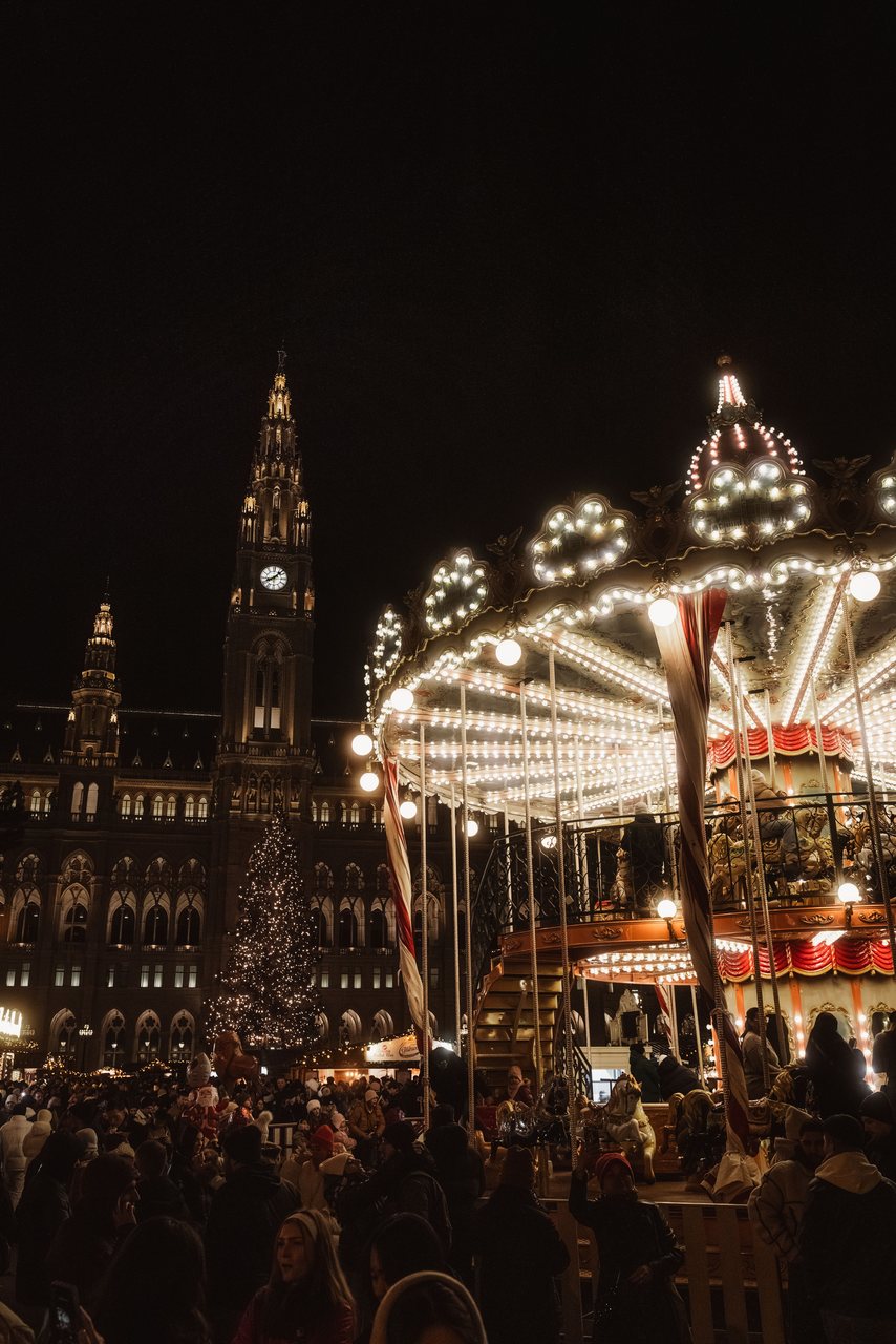 The Vienna Christmas market at Rathausplatz lit up at dusk in front of City Hall